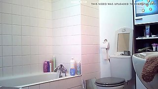 Brunette relaxes in bath and plays with her body