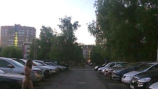 Naked woman walking on the city street in the early