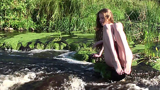Young babe Nicole stripped naked by the lake