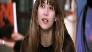 Sophie Marceau laying on a couch as a guy pulls down her
